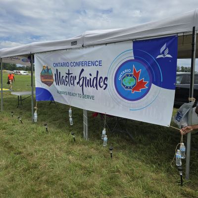 Ontario Conference Master Guides event banner at outdoor gathering.