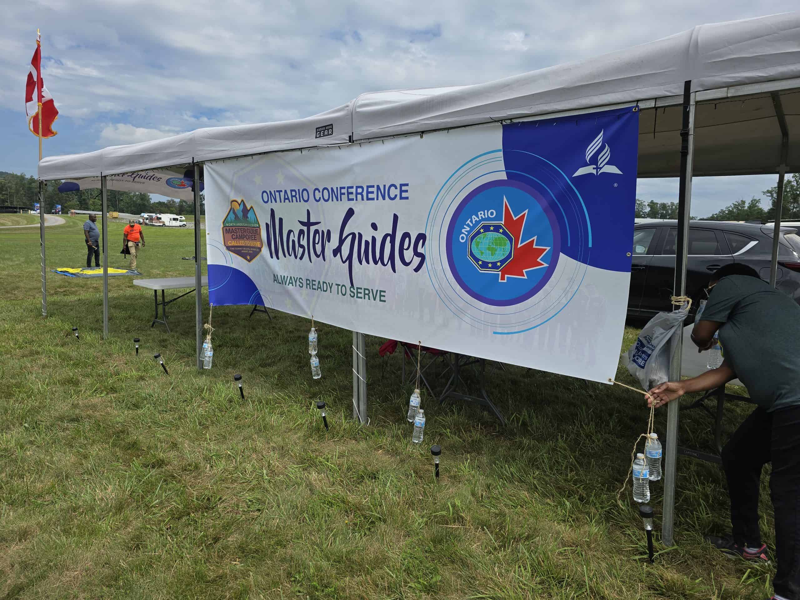 Ontario Conference Master Guides event banner at outdoor gathering.