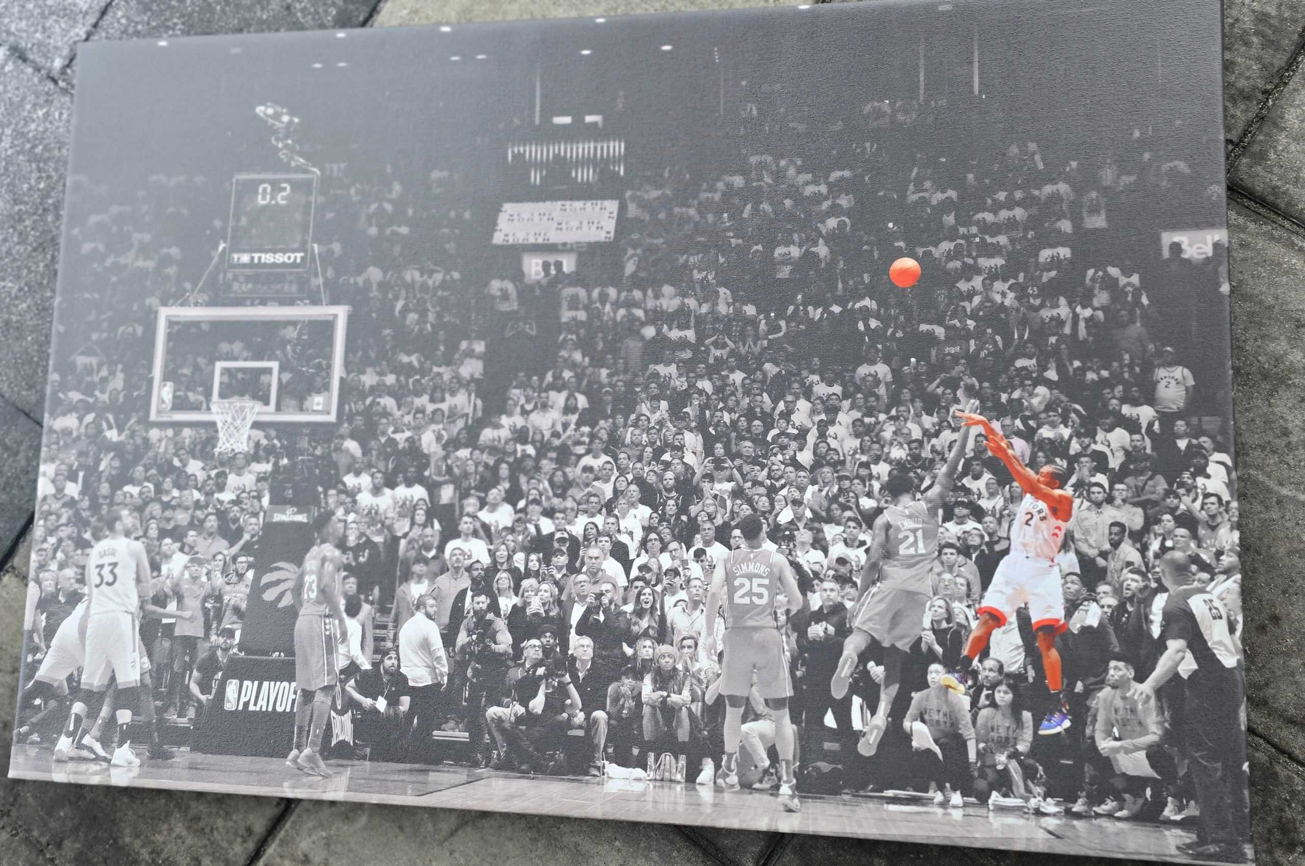 Action shot of a basketball game with players and crowd.