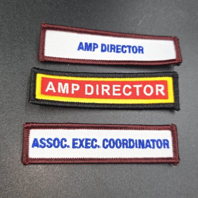 Three rectangular embroidered Pathfinder and Adventurer title patches stacked vertically: white patch with maroon border reading 