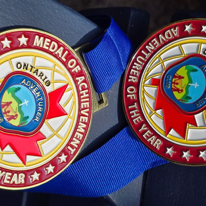 Adventurer of the Year Award - Gold medal on blue ribbon with maroon border reading 